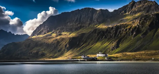 brown and green mountain beside body of water during daytime by Marek Piwnicki courtesy of Unsplash.